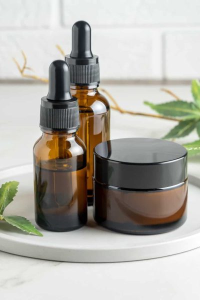 Cannabis face cream and serum or oil dropper concept. Natural cosmetic. CBD oil, THC tincture